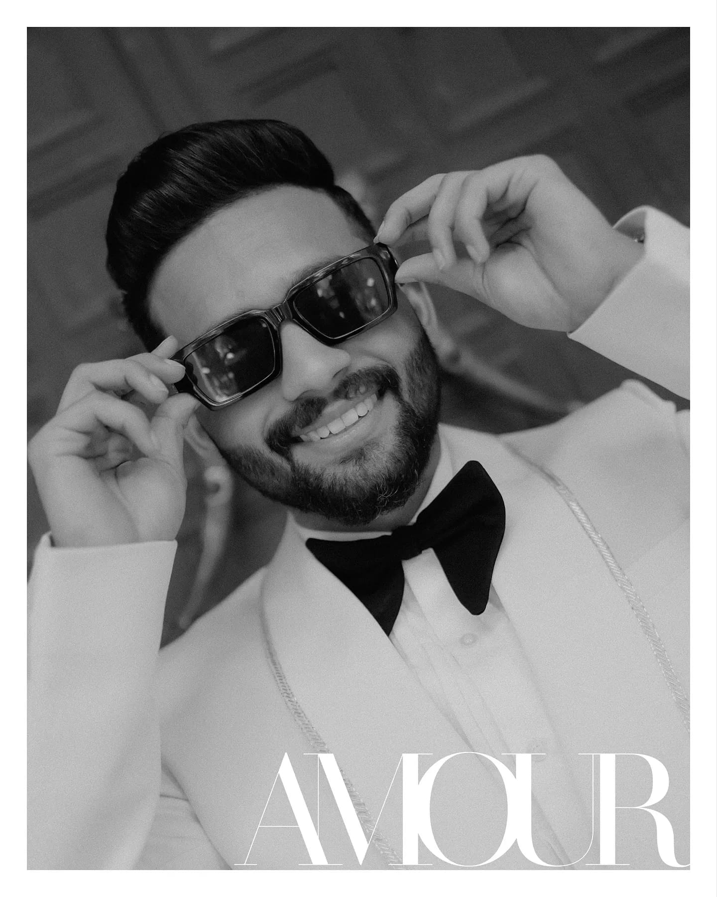 Editorial black and white portrait of a groom wearing sunglasses